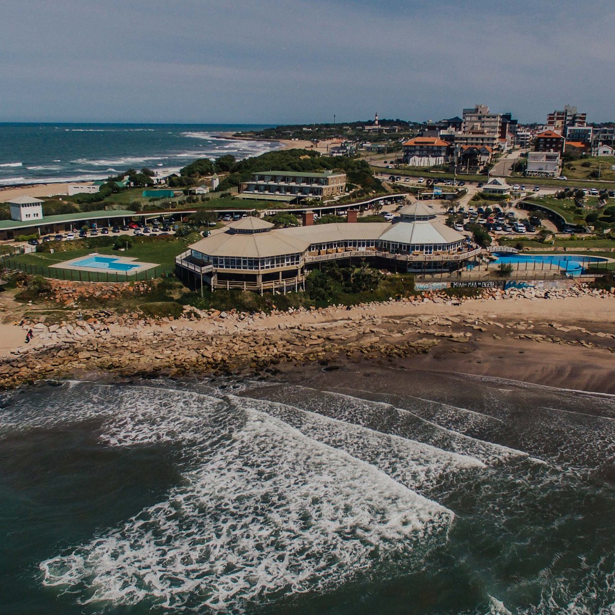 Vista aérea costera de Mar del Plata con edificios frente al mar y olas