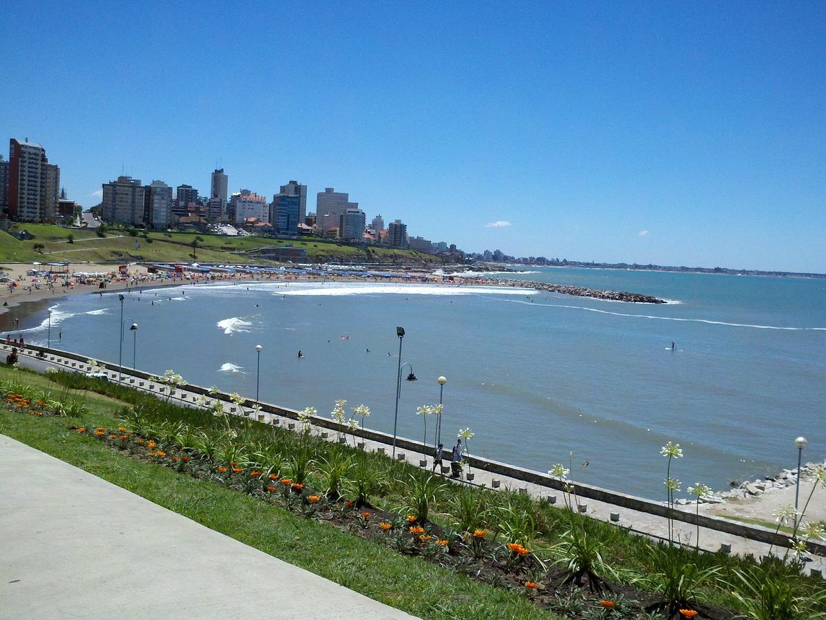 Paseo costero de Playa Grande Mar del Plata con flores y ciudad al fondo