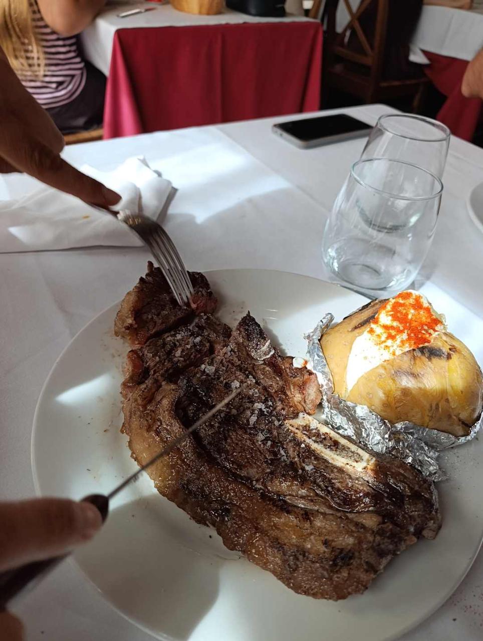 Bife de carne a la parrilla con papa asada en restaurante de Mar del Plata