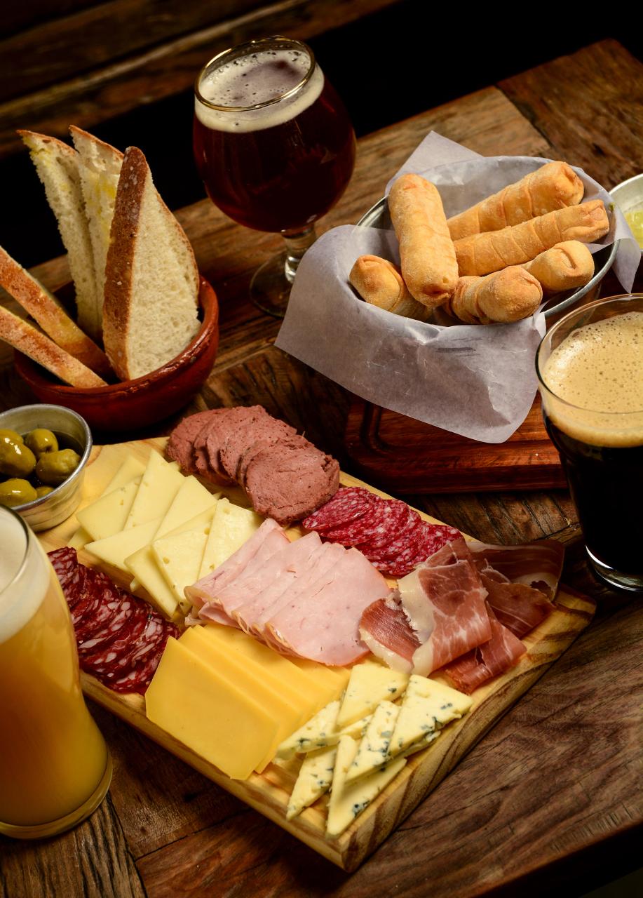 Tabla para compartir con quesos fiambres aceitunas y cerveza