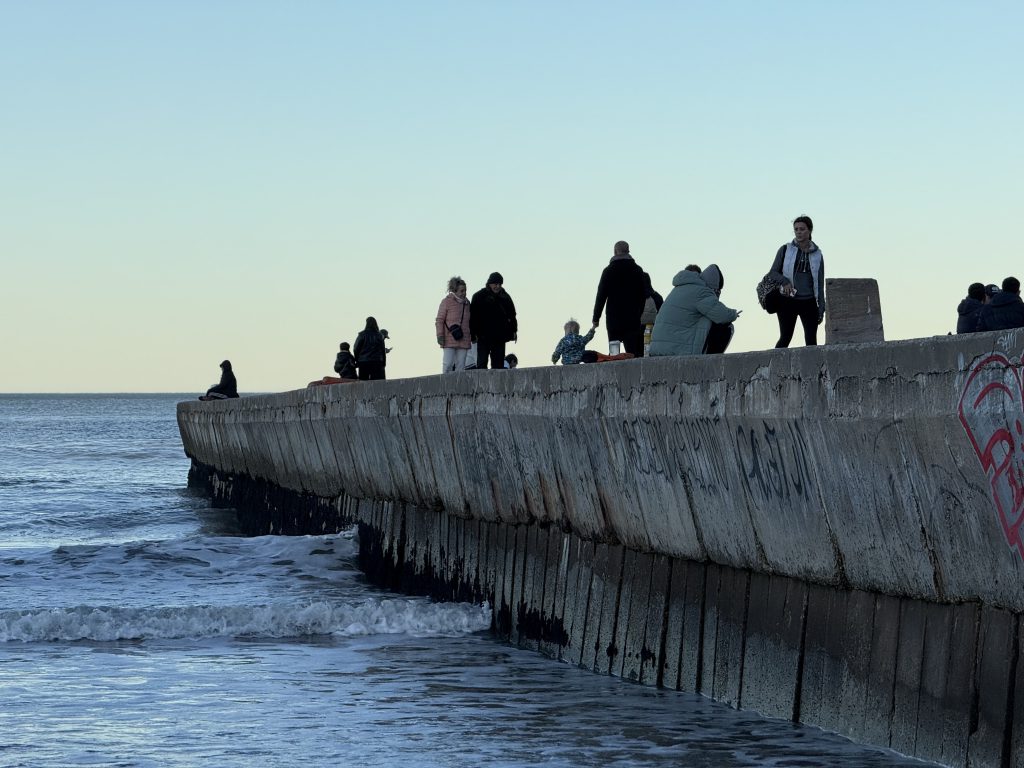 Espigón de la Playa Bristol con paseantes al atardecer en Mar del Plata