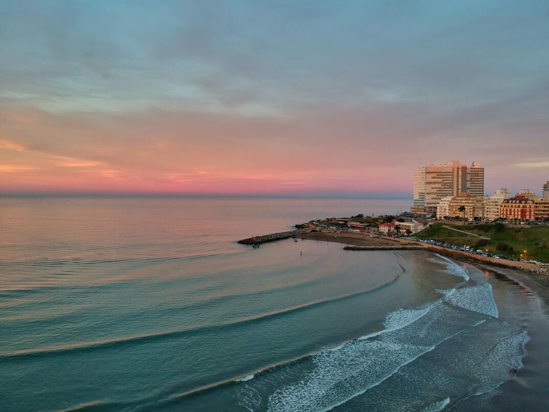 Atardecer frente al mar en Mar del Plata con cielo rosado y playa